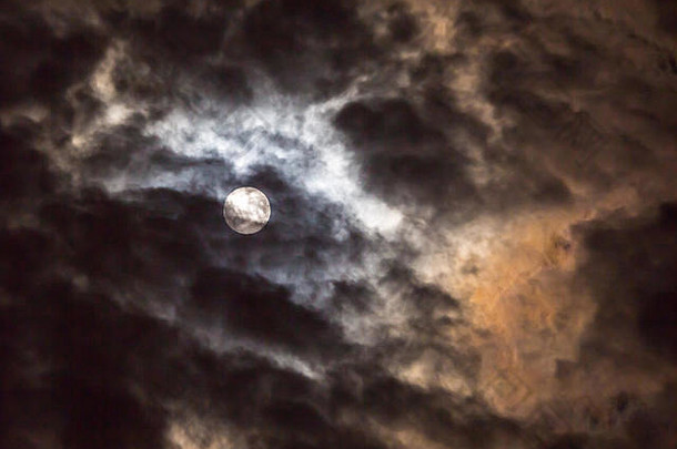 满月的光芒使夜空中的云彩引人注目。