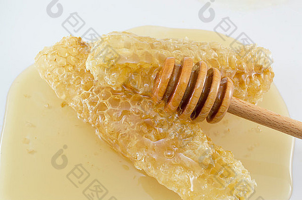 蜂巢覆盖着蜂蜜，白色的背上有勺