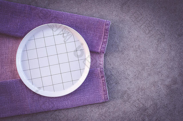 白色格子板和紫色桌布，在深色混凝土背景上，留有复印空间。