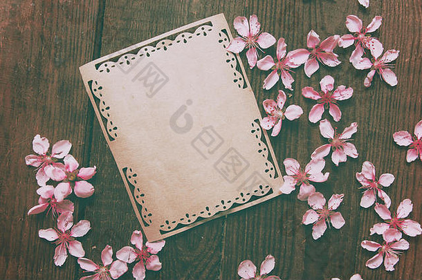 注意，明信片，在木制复古桌子上写着复古桃花，桌子背景上写着桃花。春天粉红色的花。