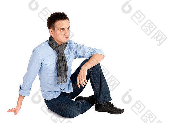 休闲年轻的男人。衬衫牛仔裤坐着地面孤立的白色背景Copyspace一边