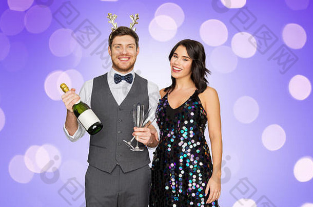 在圣诞派对上带着香槟酒瓶的情侣