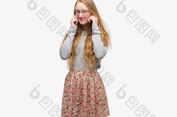 金发少女，穿着花裙子，用手指捂住耳朵，对嘈杂的音乐表示恼怒。聋哑人的概念。