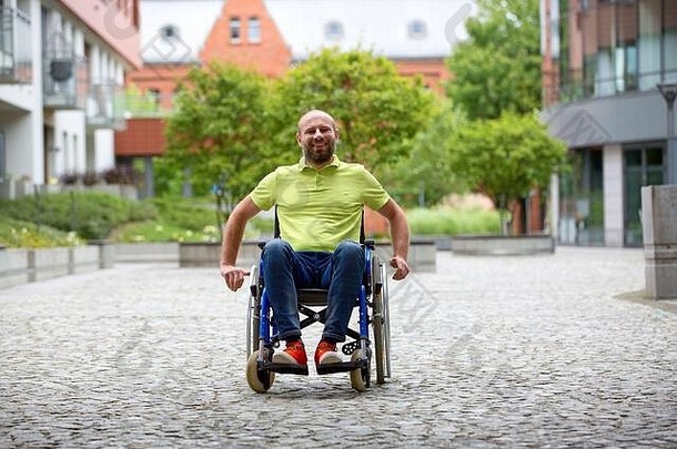 坐在城市轮椅上的快乐微笑的残疾人