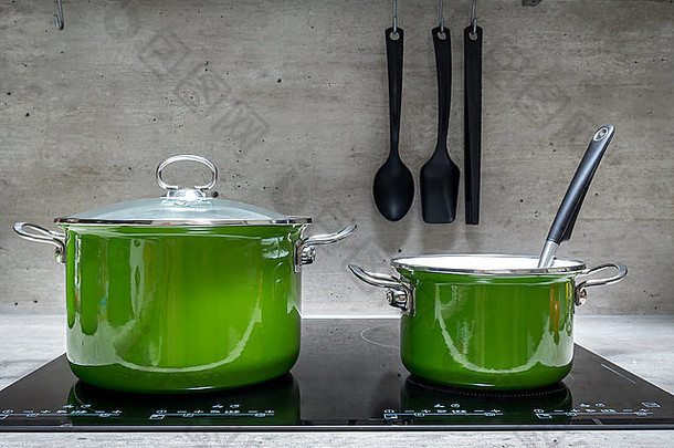 黑色电磁炉上的两个绿色搪瓷炖锅