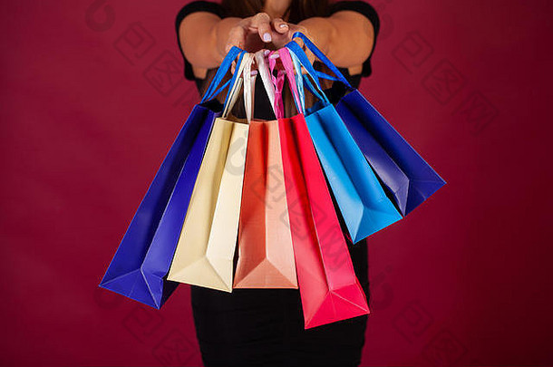 购物女人持有彩色的袋红色的背景黑色的星期五假期