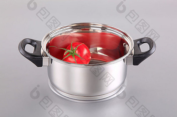 红色西红柿放在一个闪亮的不锈钢锅里