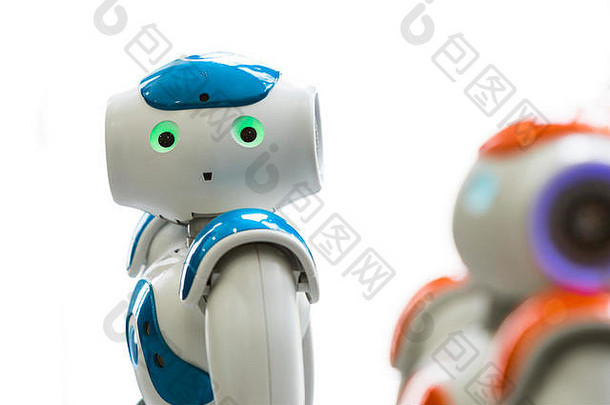 具有人脸和身体的小型机器人——仿人机器人。人工智能-人工智能。橙色和蓝色机器人隔离在白色背景上