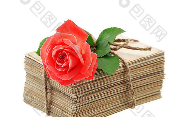 白色背景上隔离着红玫瑰花的一叠旧情书和明信片。怀旧感伤画