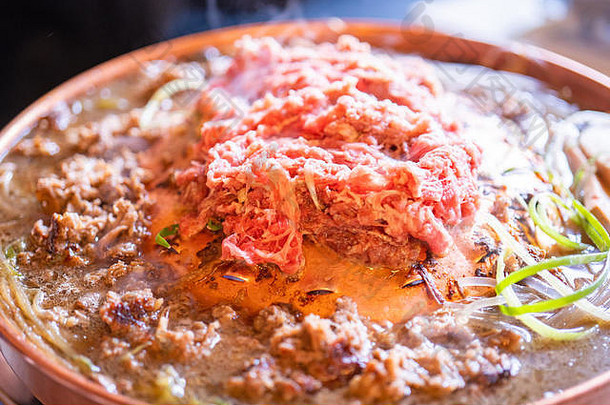 汉城韩国餐厅的牛肉烤肉bulgogi，铜锅上的生活方式新鲜韩国美食，洋葱片，特写，空间