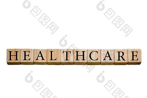 医疗保健这个词。木制小立方体，白色背景上有字母隔离，并留有复印空间。概念形象。