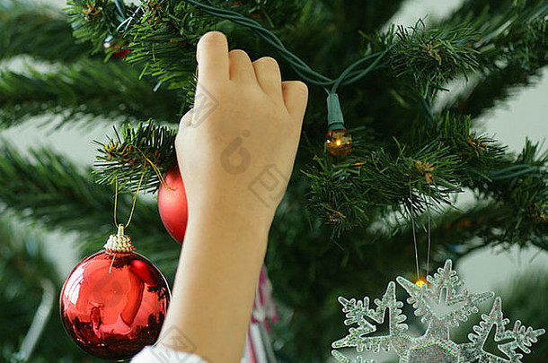 儿童手装饰圣诞树的特写镜头