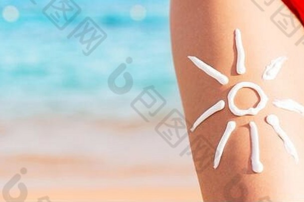 太阳形状使防晒霜女人的腿海背景