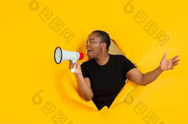 大喊大叫快乐的非裔美国人年轻的女人提出了撕裂黄色的纸背景情感富有表现力的打破breakthrought概念人类情绪面部表达式销售