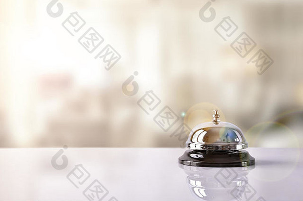 酒店服务铃放在桌子上，白色玻璃和模拟酒店背景。概念酒店、旅游、客房