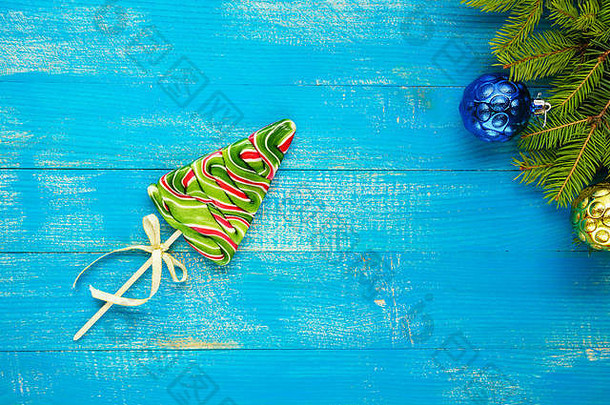 <strong>圣诞</strong>礼物：蓝色木板上的云杉形状的彩色<strong>棒棒</strong>糖。庆祝背景。