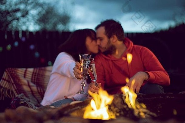 一对幸福的夫妇在篝火旁庆祝他们的结婚纪念日并亲吻。