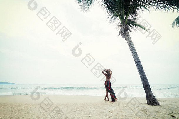 热带海滩上穿着纱笼的女人