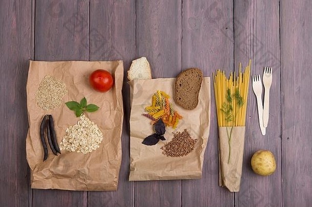 生态袋，产品富含复杂的六面体：谷物、面包、面食和蔬菜，放在木桌上