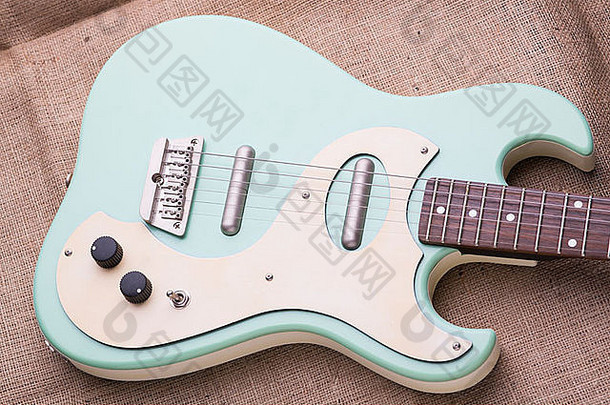 Danelectro婴儿蓝色电吉他，黑森麻袋，自然光线柔和。