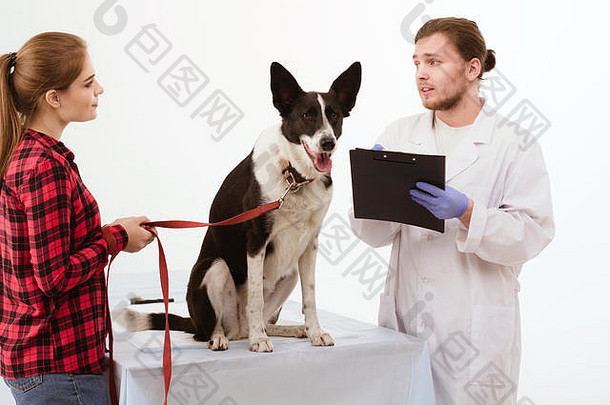 狗和它的主人在兽医诊所接受检查。