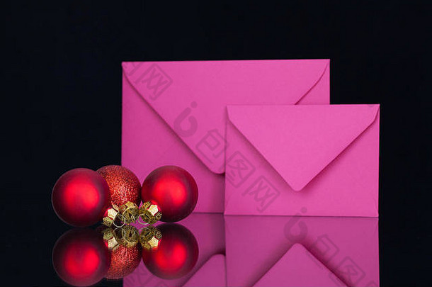 粉红色的信封圣诞节装饰黑色的玻璃表格