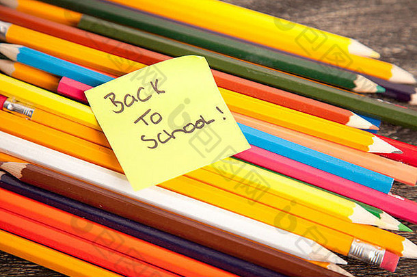 “回到学校”主题，在木制背景上展示一系列铅笔