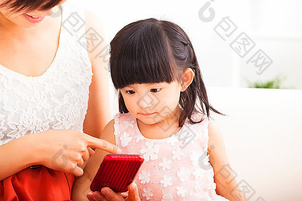 妈妈和小女孩一起在沙发上使用<strong>智能</strong>手机