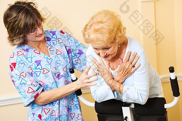 在一名护士的帮助下，一位老年妇女用脊椎<strong>按摩椅</strong>伸展脊柱。