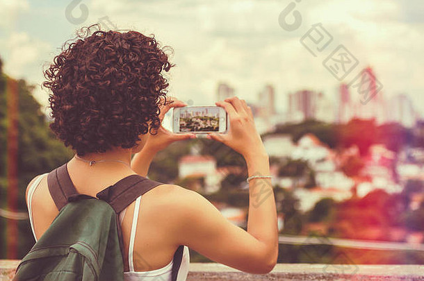 女人拍摄视图城市绿色背包