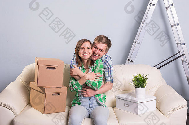 一对快乐的年轻夫妇搬进来后坐在新公寓的沙发上。