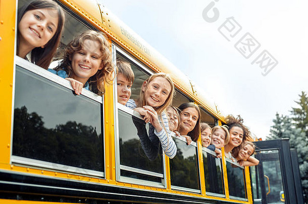 同学们<strong>坐公交</strong>车去上学，斜靠在窗外，开心地笑着