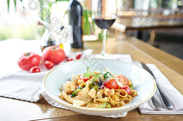 意大利通心粉配海鲜和番茄酱。甘贝里尼意大利面。特写tagliatelle用勺子把它绕在叉子上。帕尔马干酪