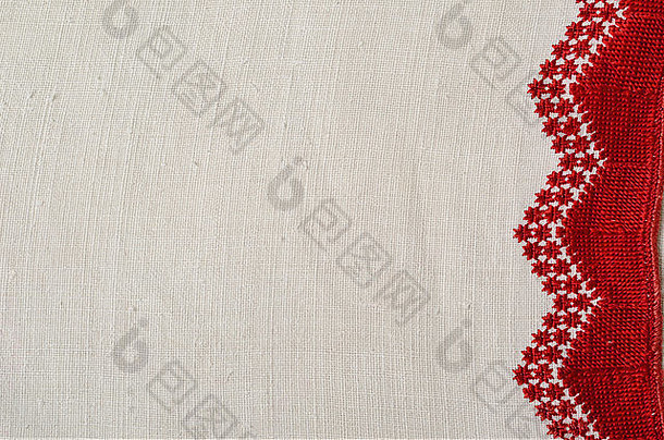 白色家纺布的右侧用手工刺绣装饰。红案是用珍珠针绣成的。Th
