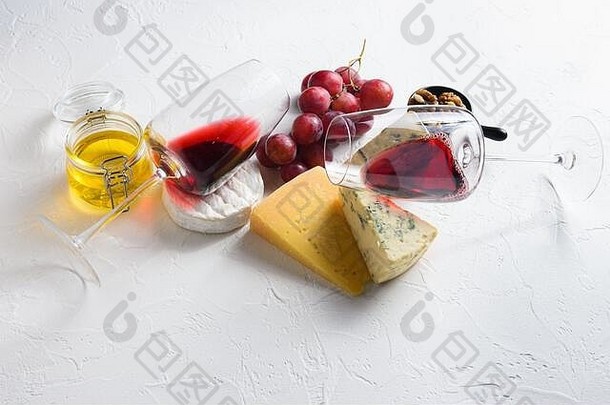 两杯红酒配奶酪开胃品或呜咽小吃套装。<strong>各种</strong>奶酪、<strong>葡萄</strong>、山核桃的侧视图空间为文字。
