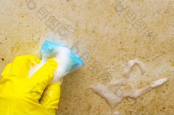 男人。黄色的保护手套洗脏浴蓝色的海绵