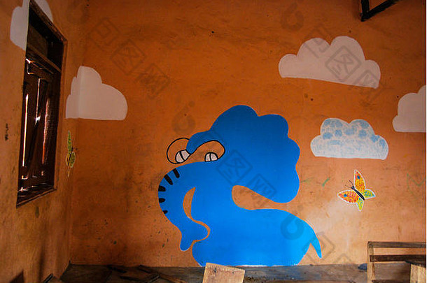 一张漂亮的蓝色大象的照片，画在加纳Kongo村当地一所小学的棕色墙上。