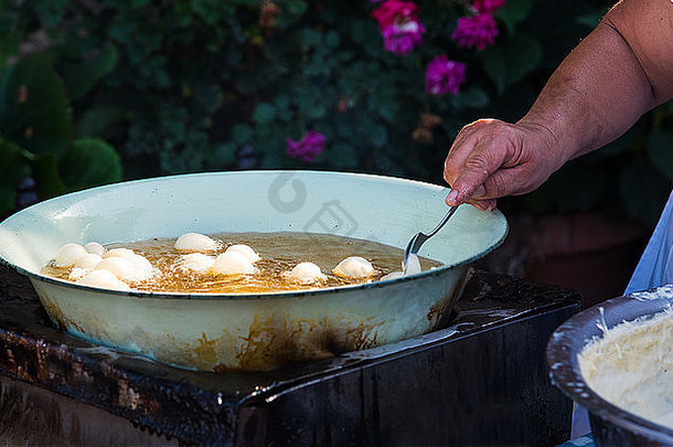 女人烹饪传统的美味的希腊洛库马迪斯蜂蜜糕点