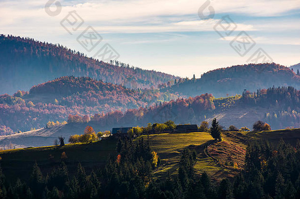 秋天，村庄坐落在长满青草的小丘上。红色森林的山区农村地区的绚丽日出