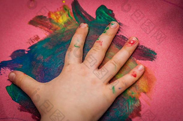 孩子手使色彩斑斓的标志着纸水彩油漆