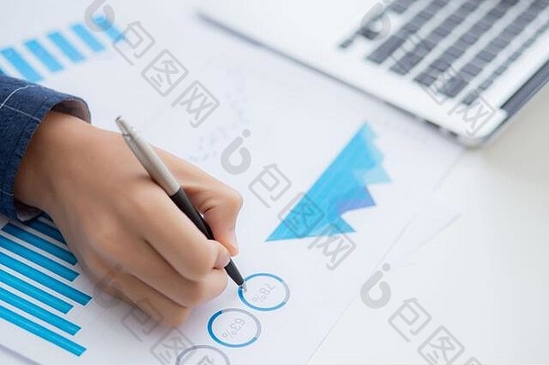 商务人员用笔指着文件数据图表的手，营销和投资，财务、经济和社会统计利润报告