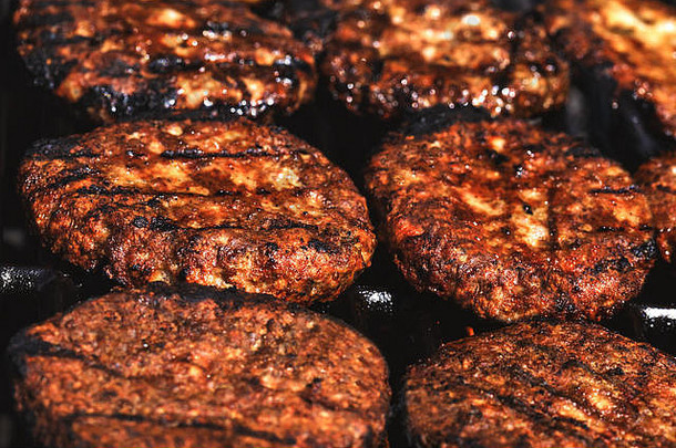 在美国餐厅前的户外烤架上烤的开胃汉堡包。完成黑色汉堡烹饪的概念图。汉堡包
