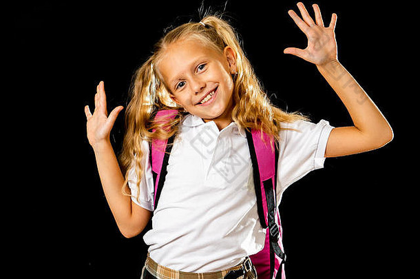 可爱美丽的小女生，带着大大的粉红色书包，在“返校”的黑色背景下感到兴奋和快乐