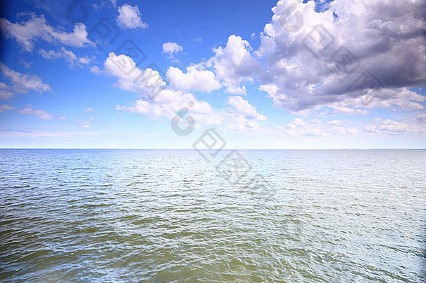 海面上的白色蓬松的云和蓝色的天空