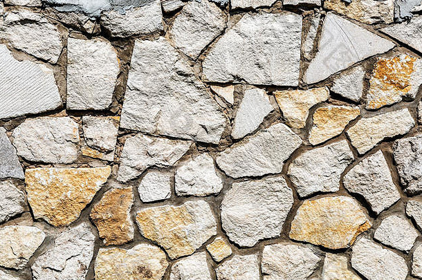 饱经风霜的灰色石头墙有创意的<strong>背景</strong>纹理自然石头砌筑不均匀接缝粗糙的石头墙纹理
