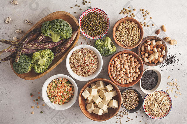 纯素蛋白质来源。白色背景上的豆腐、豆类、鹰嘴豆、坚果和种子，俯视图，空间。健康素食概念。