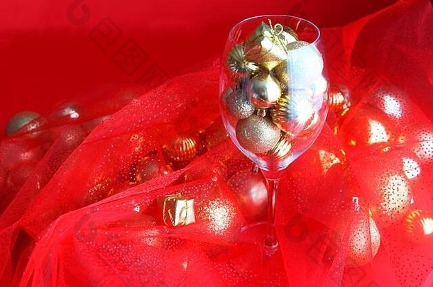 红色和金色的圣诞背景，内有葡萄藤玻璃和金色圣诞装饰。圣诞装饰藤蔓玻璃