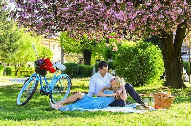 爱的感觉。相爱的一对。庆祝周年纪念。夏日公园里的快乐家庭。食物和饮料。男人和女人。一对浪漫的情侣在野餐。爱情在<strong>春</strong>天<strong>约会</strong>。在盛开的樱花下放松。