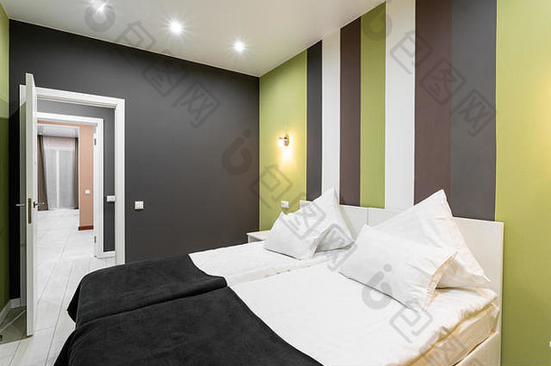 酒店<strong>标准间</strong>。带有白色枕头的现代卧室。简洁时尚的内饰。室内照明
