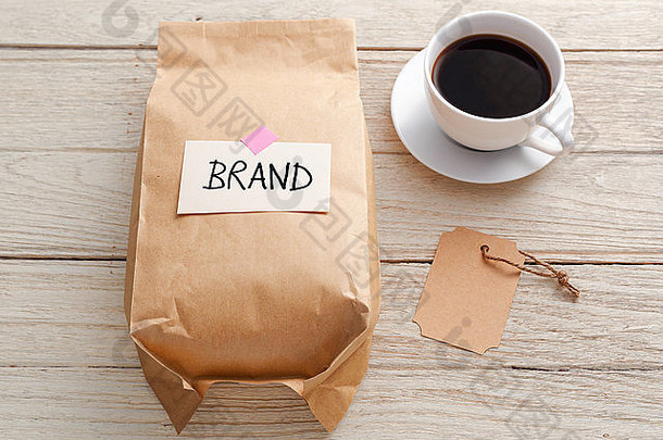 品牌营销理念，产品纸袋、品牌标签和咖啡杯放在木桌上